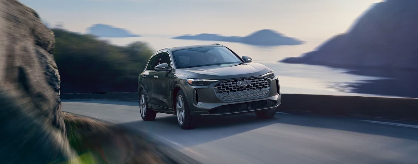 Grey 2026 Audi Q5 driving on a winding road.
